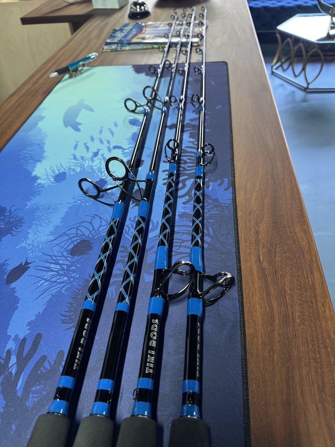 Four blue-wrapped rods resting on a table printed with marine artwork