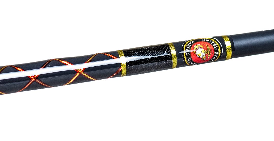 Studio close-up of a black blank with an orange cross wrap and an inlaid United States Marine Corps emblem