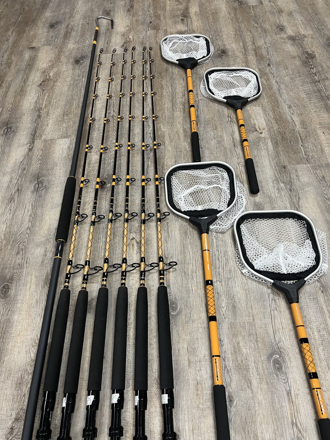 Custom landing nets with wrapped handles laid beside a matched set of gold-wrapped rods