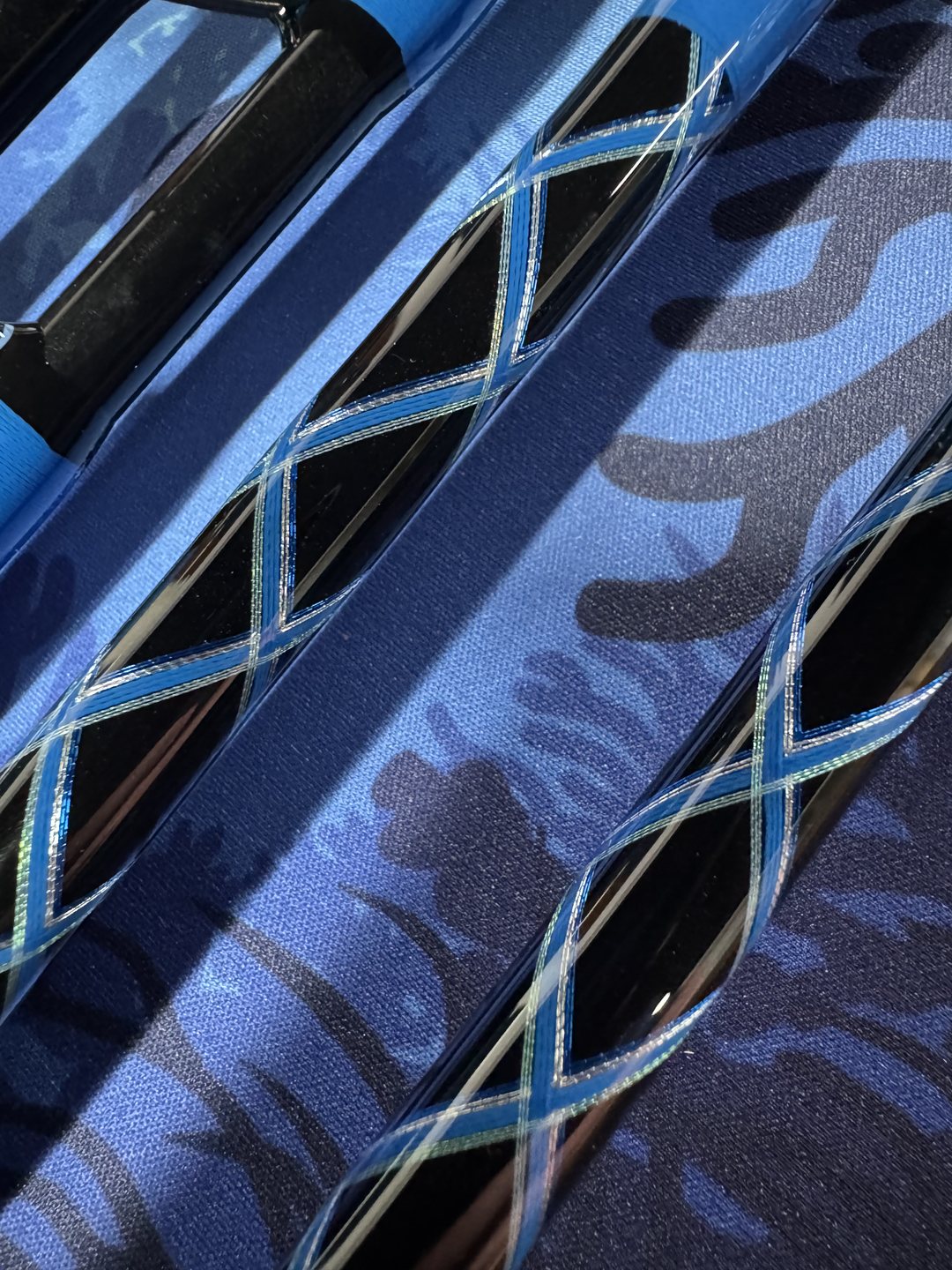 Macro of a blue and silver cross wrap laid over a blue camouflage-patterned blank